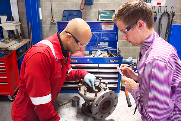 Image of Seetru training solutions practical workshop, with a training technician and a student looking over a disassembled safety valve.